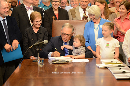Gov. Jay Inslee signs a bill Thursday to create the new Washington State Department of Children, Youth and Families. (Official Governor’s Office Photo)